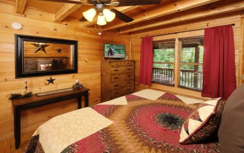a bedroom with a bed and a dresser in a cabin at Chardonnay Getaway in Pigeon Forge