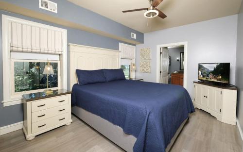 a bedroom with a blue bed and a tv at The Smoky Mountain Nest in Pigeon Forge