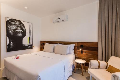 a hotel room with a bed and a chair at Triângulo Noronha in Fernando de Noronha
