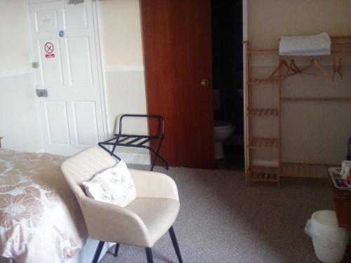 a bedroom with a chair and a bed and a closet at The Merchants House in Cairnryan