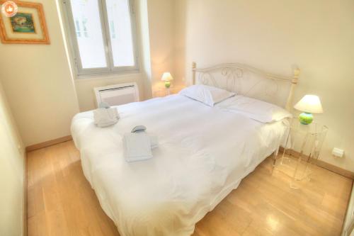 - une chambre avec un lit blanc et 2 boîtes dans l'établissement ALC - FONT3 - 10 min PALAIS, à Cannes