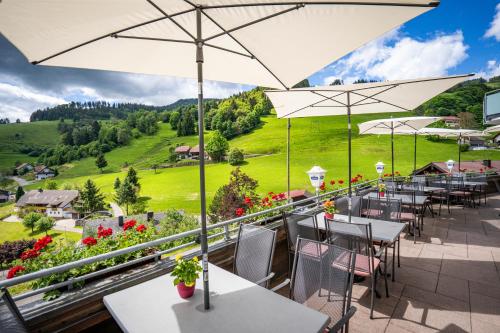 a patio with tables and chairs and umbrellas at Schwarzwald Hotel Wiedenerhof in Wieden