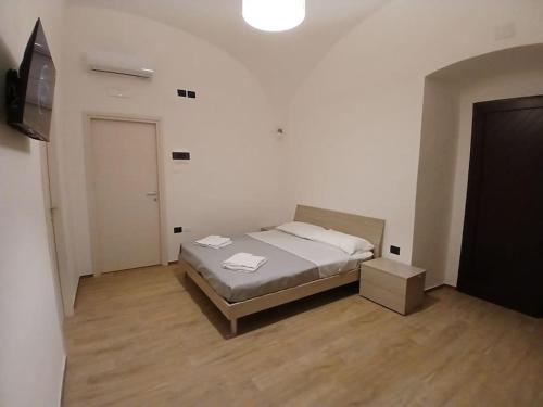 a bedroom with a bed and a flat screen tv at AB House Caserta - Reggia di Caserta e Stazione Fs a cinque minuti in auto in Caserta
