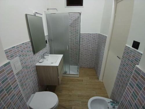 a bathroom with a toilet and a sink and a mirror at AB House Caserta - Reggia di Caserta e Stazione Fs a cinque minuti in auto in Caserta