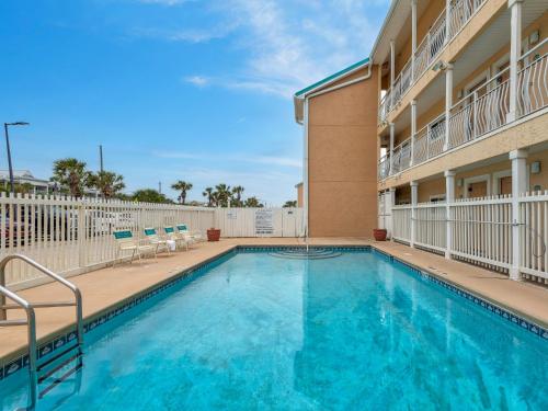 a swimming pool with chairs and a building at Crystal Sands 103A by Newman-Dailey in Destin