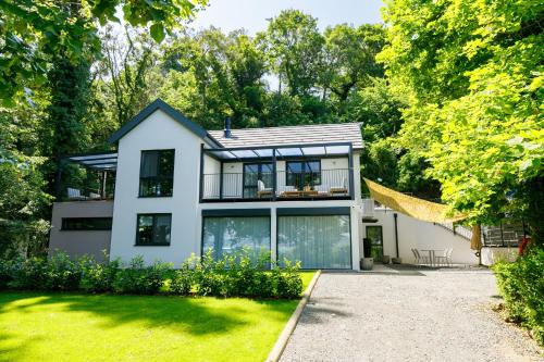 a white house with a lot of windows at Aquilo Apartmanok in Tihany
