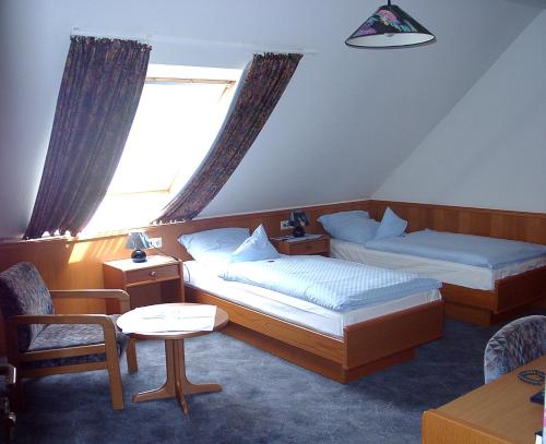 a hotel room with two beds and a window at Landgasthof Dockemeyer in Hollenermoor