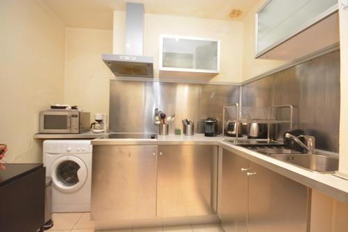 une cuisine avec un évier et une machine à laver dans l'établissement Studio Saint Germain, à Paris