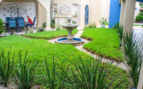 a garden with a fountain in the middle of a yard at Serenity Home Hospedaje con confort y seguridad in Mérida