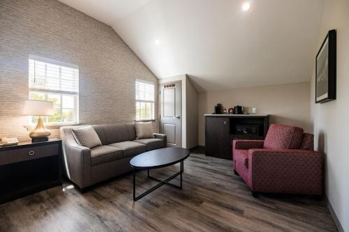 a living room with a couch and a chair and a table at Normandy Farm Hotel & Conference Center in Blue Bell
