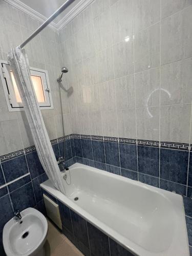 a bathroom with a bath tub and a toilet at Yousa Home & pool in Gzennaïa