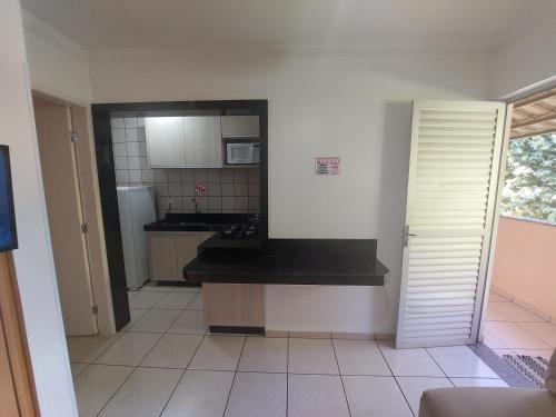 a kitchen with a black counter top in a room at diRoma Fiori - Apartamentos JN in Caldas Novas