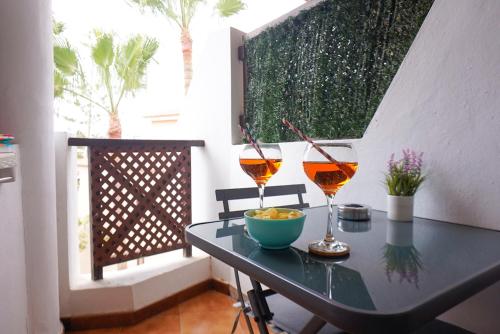サンミゲル・デ・アボナにあるSweet home ocean golf resortの- バルコニーのテーブルにワイン2杯