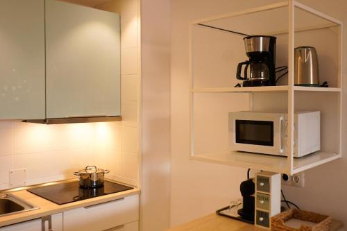 サンミゲル・デ・アボナにあるSweet home ocean golf resortの白いキャビネットと電子レンジを備えたキッチン