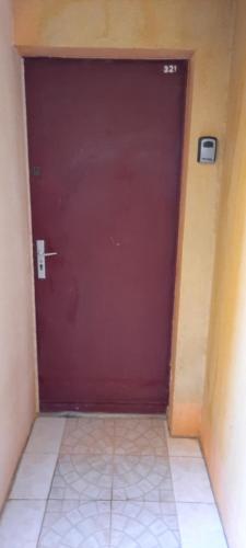 une porte de garage rouge dans une pièce avec un sol carrelé dans l'établissement Vacances à Narbonne Plage !, à Narbonne