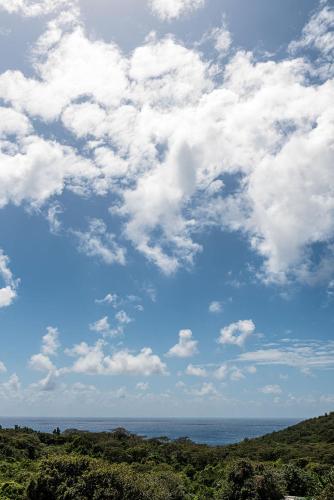 a blue sky with white clouds over the ocean at Triângulo Noronha in Fernando de Noronha