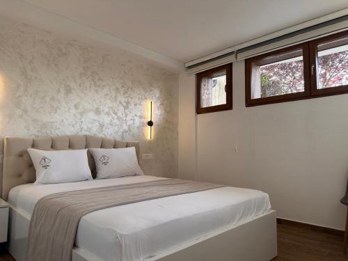a bedroom with a large white bed with two pillows at Treva Hotel & Apartaments in Prizren