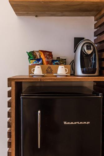 a microwave sitting on a shelf above a refrigerator at Triângulo Noronha in Fernando de Noronha