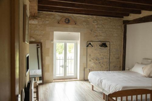 a bedroom with a bed and a window at Grande maison, piscine. 15 personnes. Sancerre in Gardefort