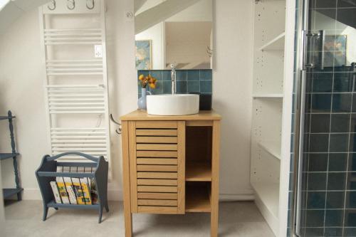 a bathroom with a sink and a wooden cabinet at Grande maison, piscine. 15 personnes. Sancerre in Gardefort