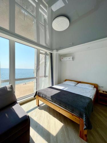 a bedroom with a bed and a view of the ocean at Volna in Odesa