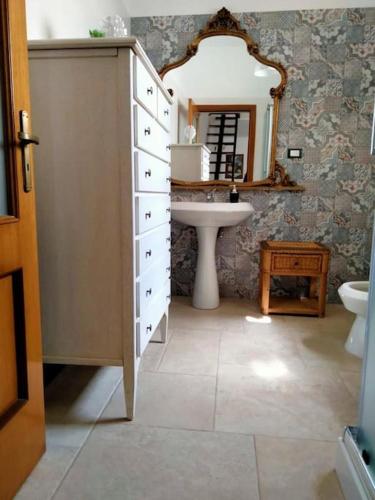 a bathroom with a sink and a dresser with a mirror at Casa vacanza La Dimora in San Pancrazio Salentino