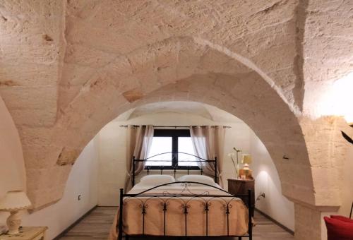 a bedroom with a bed in a stone wall at Casa vacanza La Dimora in San Pancrazio Salentino