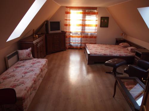 a attic bedroom with two beds and a tv at Apartment Najadka in Bobrovec