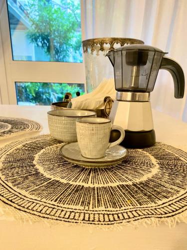 a blender and two cups on a table at Suite con giardino Ravenna in Ravenna