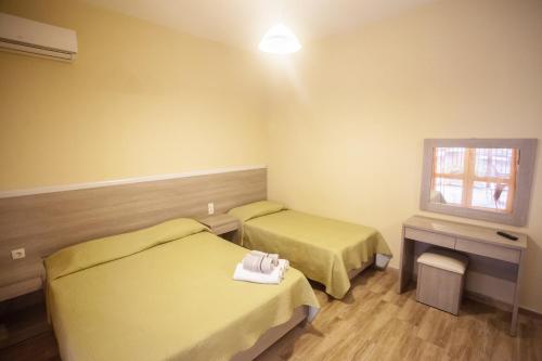 a hotel room with two beds and a window at Villa Herkules in Olympiaki Akti