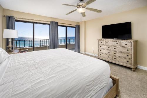 una camera da letto con un letto grande e una TV a schermo piatto di Surf Dweller 510 a Fort Walton Beach