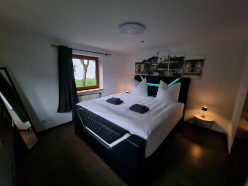 a bedroom with a large white bed with a window at Ferienwohnung "Seaside" in Lindenberg im Allgäu
