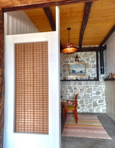 a door leading into a room with a stone wall at Rahoni Park & Suites in Dhërmi
