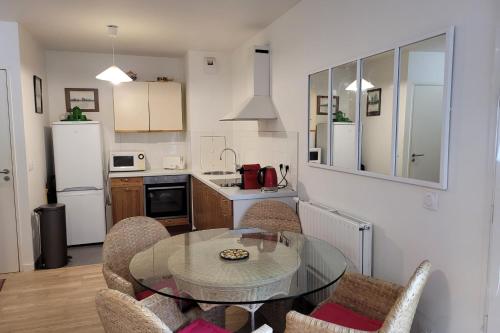 une cuisine avec une table et des chaises dans une pièce dans l'établissement Nice T2 with balcony near Paris, à Ivry-sur-Seine