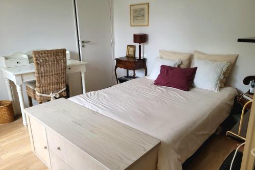 une chambre avec un grand lit blanc avec des oreillers dans l'établissement Nice T2 with balcony near Paris, à Ivry-sur-Seine