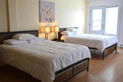 two beds in a hotel room with two lamps at Parc du Mont-Citadelle in Saint-Honoré-de-Témiscouata