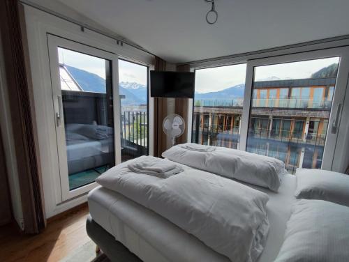 two beds in a room with a large window at Alpinoase City Centre Zell am See in Zell am See