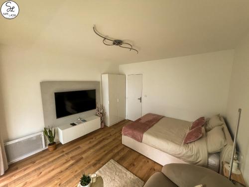 une chambre avec un lit et une télévision à écran plat dans l'établissement Suite Laosk, à Pornichet