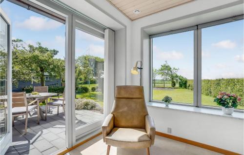 a living room with large windows and a chair at Awesome Home In Vestervig With Wifi in Vestervig