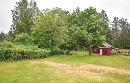 a small red shed in the middle of a yard at Two-Bedroom Holiday Home In Nassjo in Nässjö