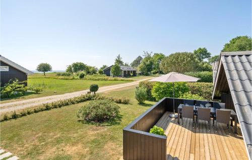 an outdoor deck with a table and chairs and an umbrella at Holiday Home Birkely Nysted Iv in Nysted