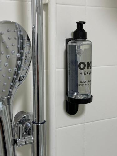 a soap dispenser on a wall next to a sink at Oktheway Caldas Centro in Caldas de Reis