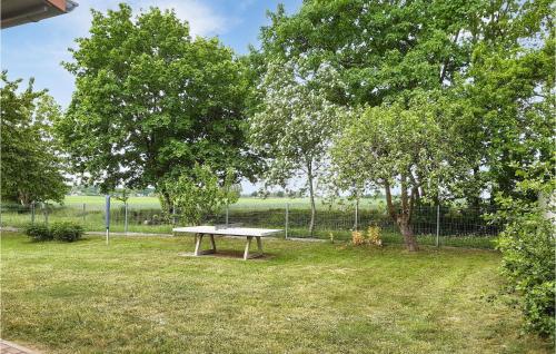 a picnic table in the middle of a field with trees at Cozy Home In Behrenhoffneu Dargel 