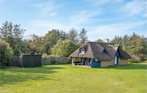 an old house with a thatched roof in a yard at Holiday Home Thyholm 12 in Thyholm