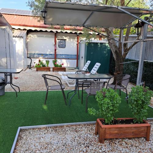 a patio with a table and chairs and an umbrella at For Nature Lovers 2 in Skala Rachoniou