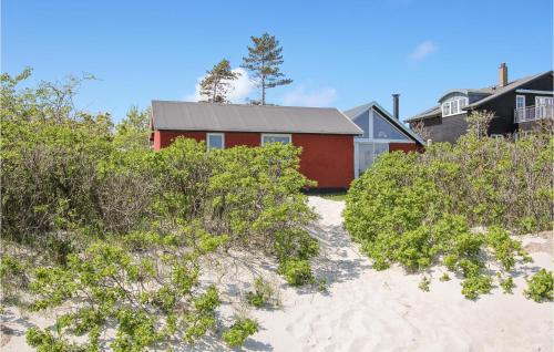 a red house on the beach with bushes at Beautiful Home In Samsø With Kitchen in Ballen