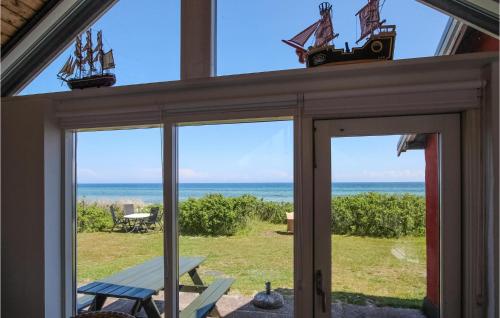 a screened in porch with a view of the ocean at Beautiful Home In Samsø With Kitchen in Ballen