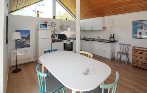 a kitchen and dining room with a white table and chairs at Beautiful Home In Samsø With Kitchen in Ballen