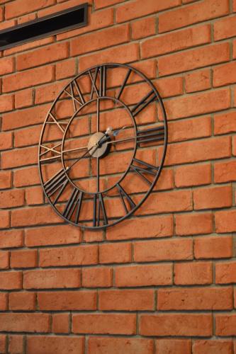 a clock on the side of a brick wall at Leśny Zakątek Kownatki 42 in Kozłowo
