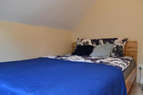 a bedroom with a bed with blue sheets and pillows at Leśny Zakątek Kownatki 42 in Kozłowo